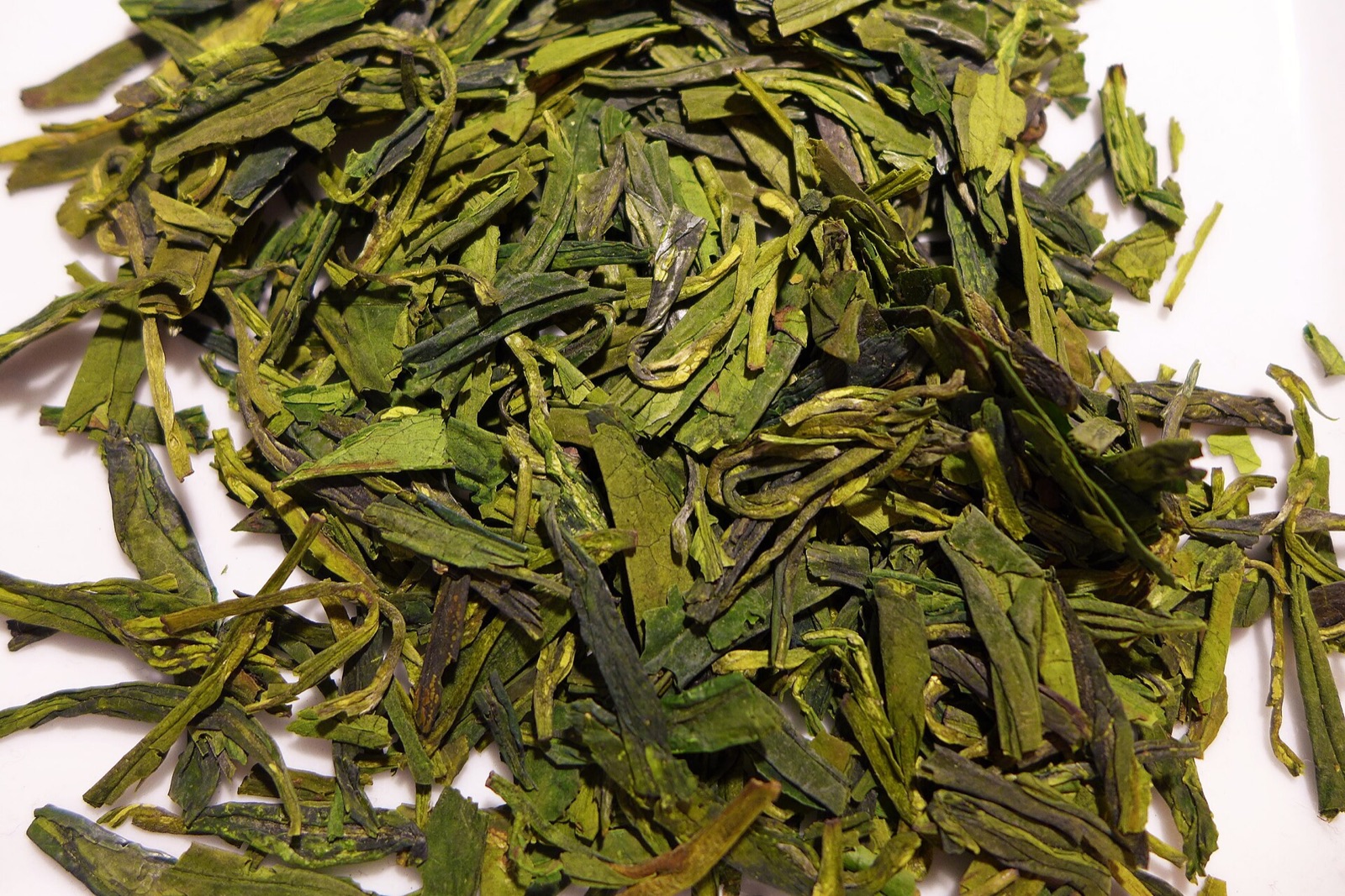 Flat Longjing tea leaves and brewed cup